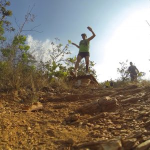 Daniela Martucci saltando mientras corre en la montaña en un día soleado